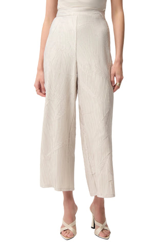 Person wearing beige ribbed pants on a white background