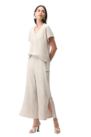 Woman wearing a beige outfit with a plain background