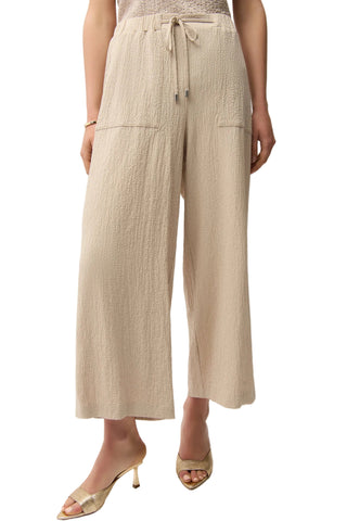 Beige wide-leg pants worn by a person on a white background