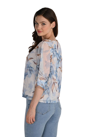 Woman wearing a floral blouse and jeans on a white background