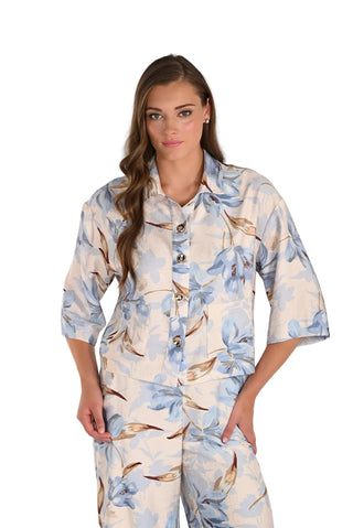Woman wearing a floral pajama set against a white background