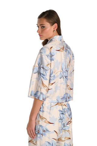 Woman wearing a floral kimono-style garment against a plain background