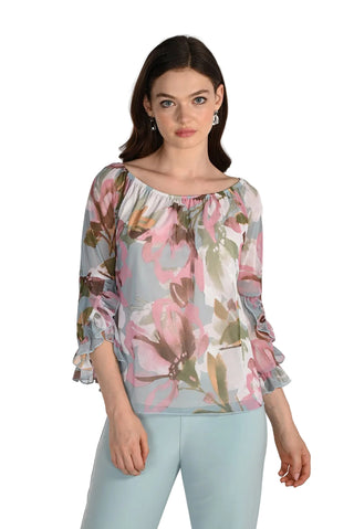 Woman wearing a floral blouse and light blue pants on a white background