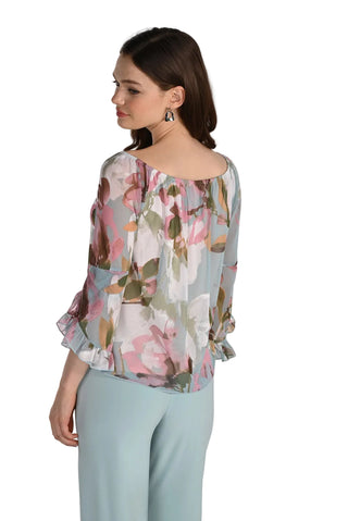 Woman wearing a floral blouse and light blue pants on a white background