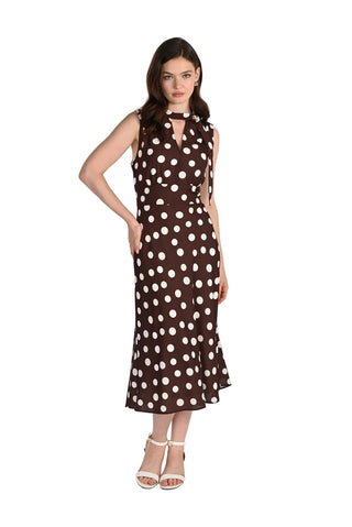 Woman wearing a brown dress with white polka dots on a white background