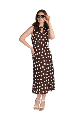 Woman wearing a brown dress with white polka dots against a white background