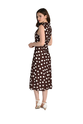 Woman wearing a brown dress with white polka dots on a white background