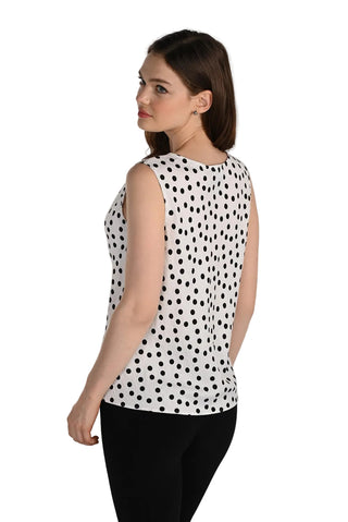 Woman wearing a sleeveless polka dot top on a white background