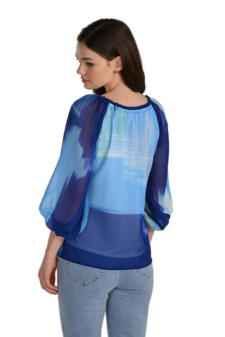 Woman wearing a blue and white blouse with sheer sleeves on a white background