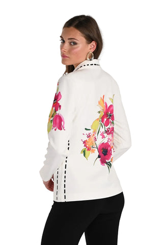 Woman wearing a white jacket with colorful floral designs on a plain background