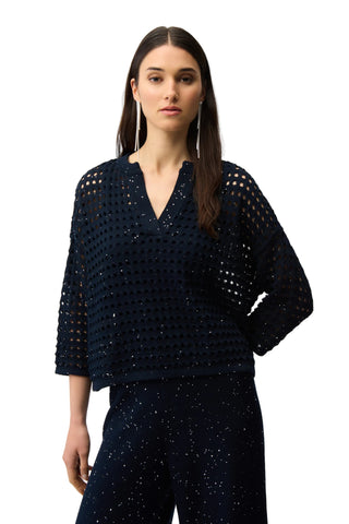 Woman wearing a dark blue textured top and pants on a white background