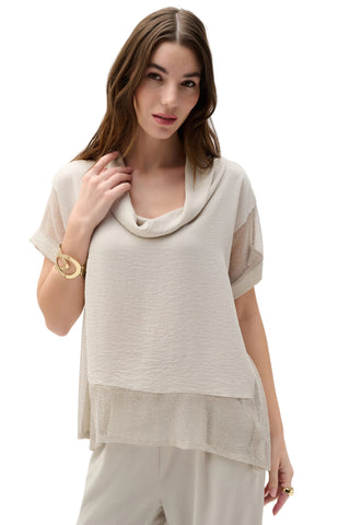 Woman wearing a beige layered top and pants on a white background