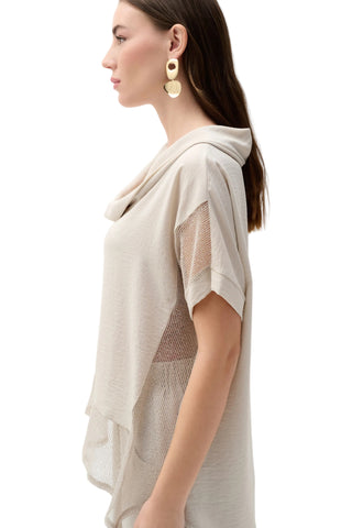 Woman wearing a beige mesh top with a plain white background