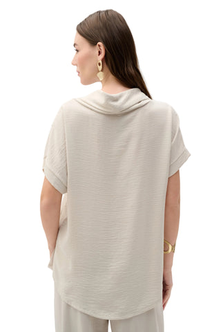 Woman wearing a light gray top and pants on a white background