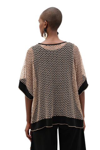 Woman wearing a patterned top with black trim on a white background