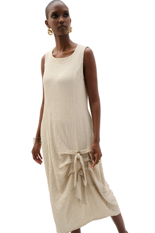 Woman wearing a beige sleeveless dress on a white background