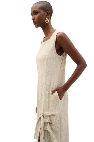 Woman wearing a beige sleeveless dress on a white background