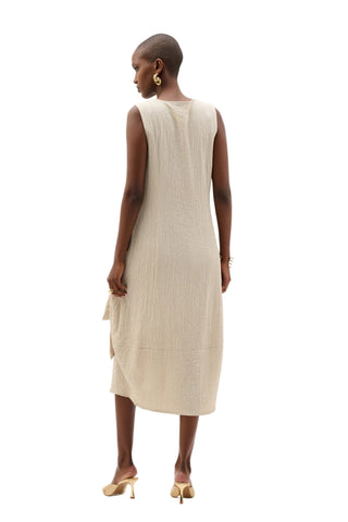 Woman wearing a beige sleeveless dress on a white background