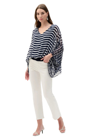 Woman wearing a black and white striped sweater with a patterned bag on a white background