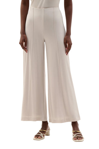 Person wearing beige wide-leg pants on a white background