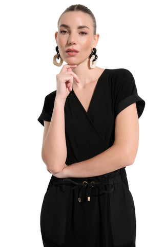 Woman wearing a black outfit with a plain background