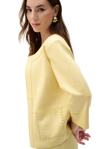 Woman wearing a light yellow outfit with a plain background