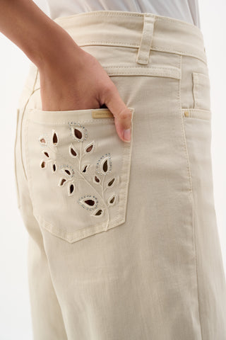 Beige pants with decorative pocket detail on a white background