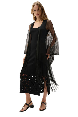 Woman wearing a black dress with sheer sleeves on a white background