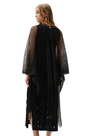 Woman wearing a black dress with sheer sleeves on a white background