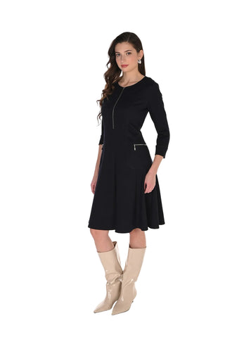 Woman wearing a black dress with long sleeves and beige boots on a white background