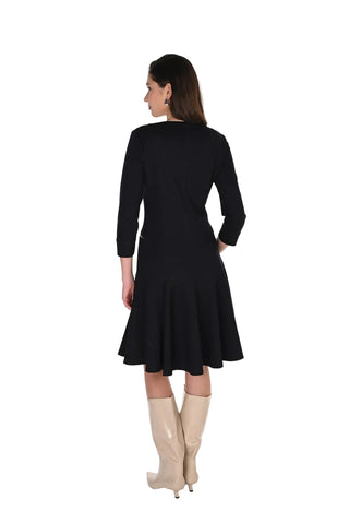 Woman wearing a black dress with beige boots on a white background