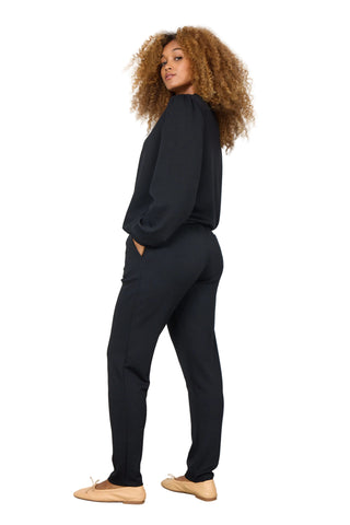 Woman wearing a black outfit against a white background