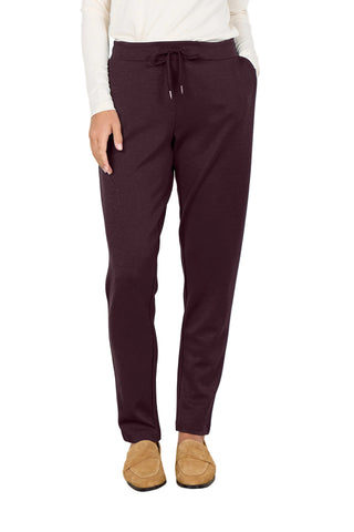 Person wearing maroon jogger pants and brown shoes on a white background