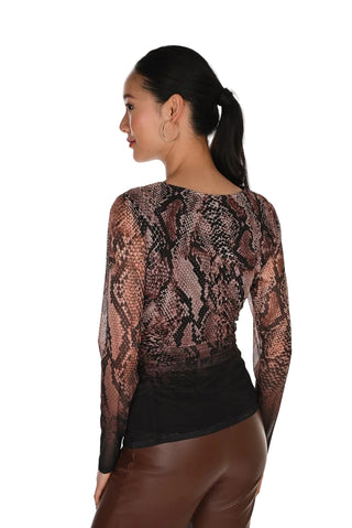 A woman shown from the back wearing a sheer long-sleeve top with a snakeskin pattern in brown, black, and beige tones, paired with brown faux-leather pants, against a plain white background.