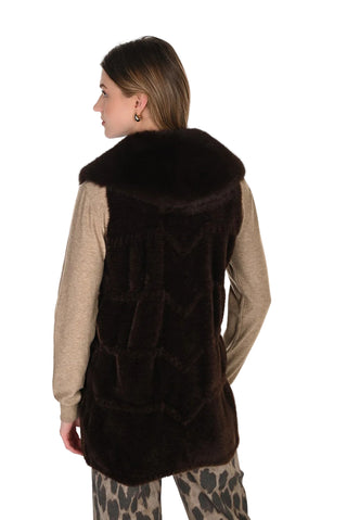 Woman wearing a brown fur vest on a white background