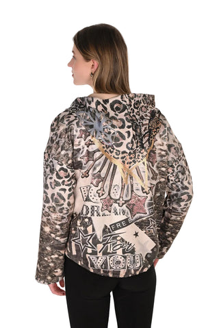 A woman shown from the back wearing a hooded jacket with a mixed animal-print and graphic collage design in beige, brown, black, and gray tones, paired with black pants against a plain white background.