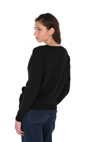 A woman shown from the back wearing a black long-sleeve knit sweater and dark blue jeans, photographed against a plain white studio background.