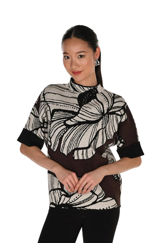 Woman wearing a black and white patterned top on a white background