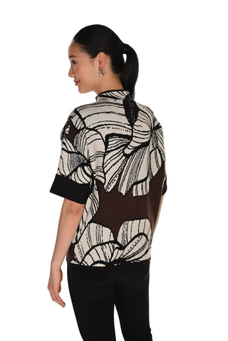 Woman wearing a black and white patterned blouse on a white background