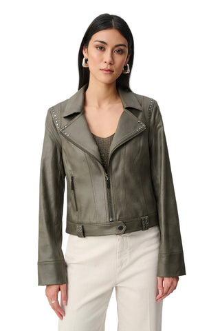Woman wearing a green leather jacket on a white background