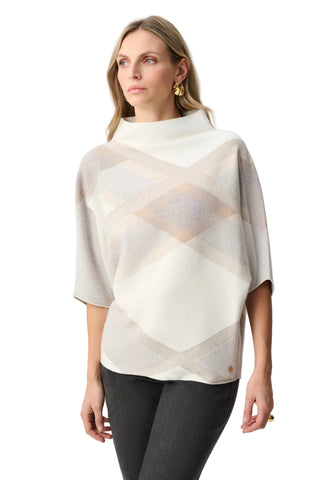 Woman wearing a patterned poncho against a white background