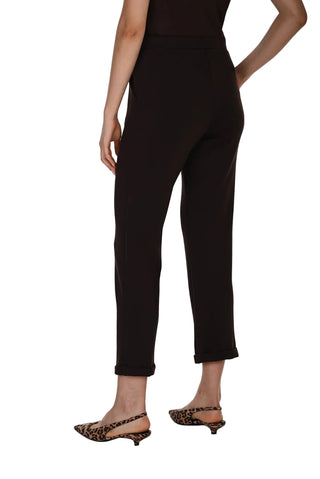 A model shown from the back wearing black cropped trousers and leopard-print slingback kitten heels against a white studio background.