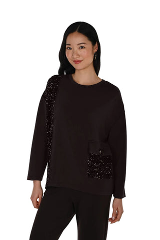 Woman wearing a black outfit with sequin details on a white background