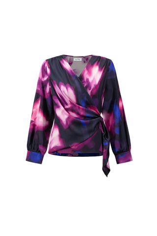 A long-sleeve wrap blouse with a vibrant purple, pink, and blue abstract floral pattern on a black base, featuring a tie waist and a V-neckline, shown against a light gray background.