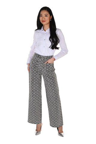 Woman wearing a white blouse and patterned gray pants on a white background