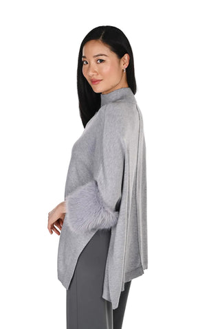 Woman wearing a gray poncho on a white background