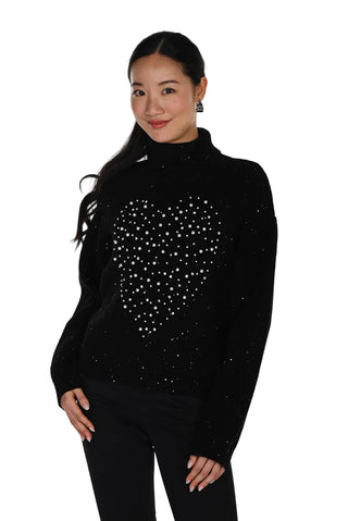 Woman wearing a black turtleneck sweater with a heart design on a white background