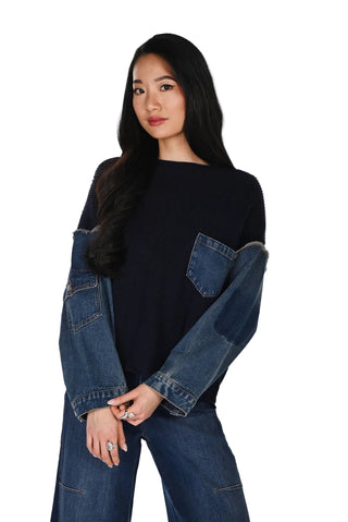 Woman wearing a black sweater with denim sleeves on a white background