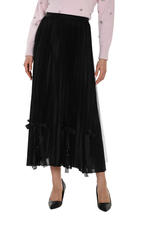 Black pleated skirt worn with a light pink blouse on a white background