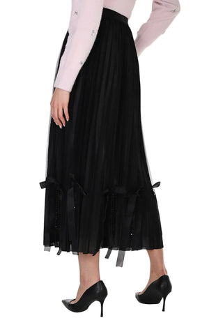 Black skirt with ruffled layers worn by a person on a white background